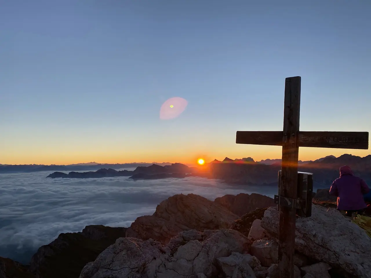 Sonnenaufgang am Gipfelkreuz über dem Nebelmeer
